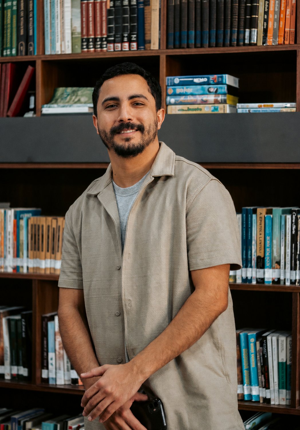 Jonatan Terra em frente a uma estante de livros
